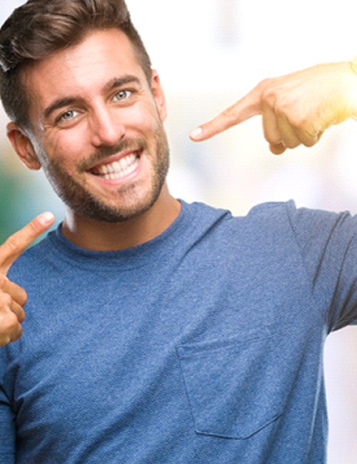 Man pointing to his smile after teeth whitening in Temple, TX