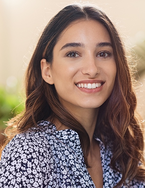 Young smiling after talking with her bilingual dental team