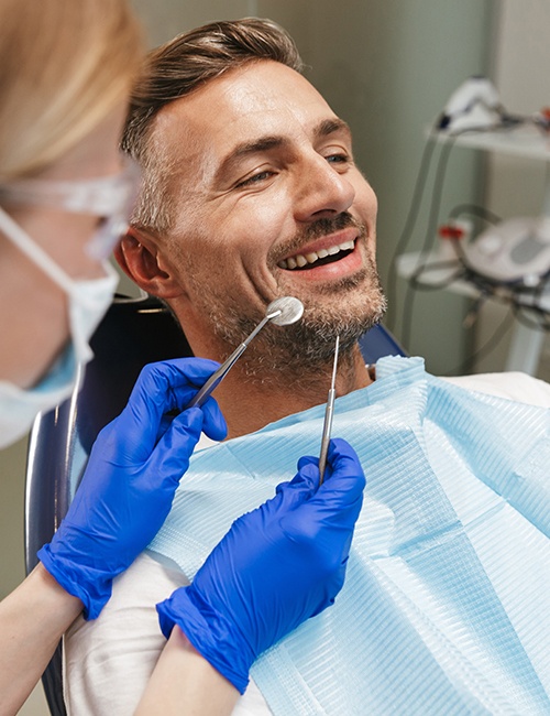 Dentist checking patient's smile after one visit dental restoration treatment