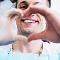 patient and dentist making heart shape with hands