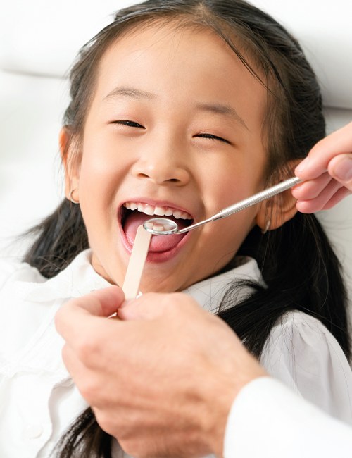 Young girl receiving dental checkup and teeth cleaning