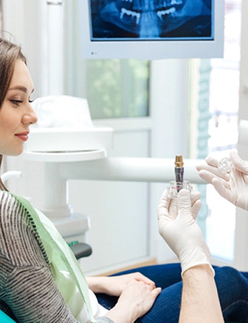 dentist explaining how dental implants work to a patient