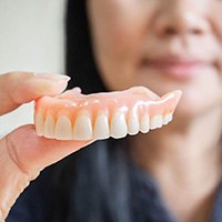 Woman holding dentures