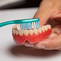 Man brushing dentures