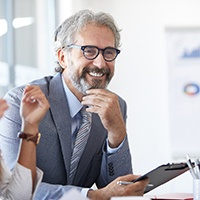 A senior businessman working alongside colleagues