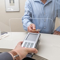 An older man paying the cost of dentures