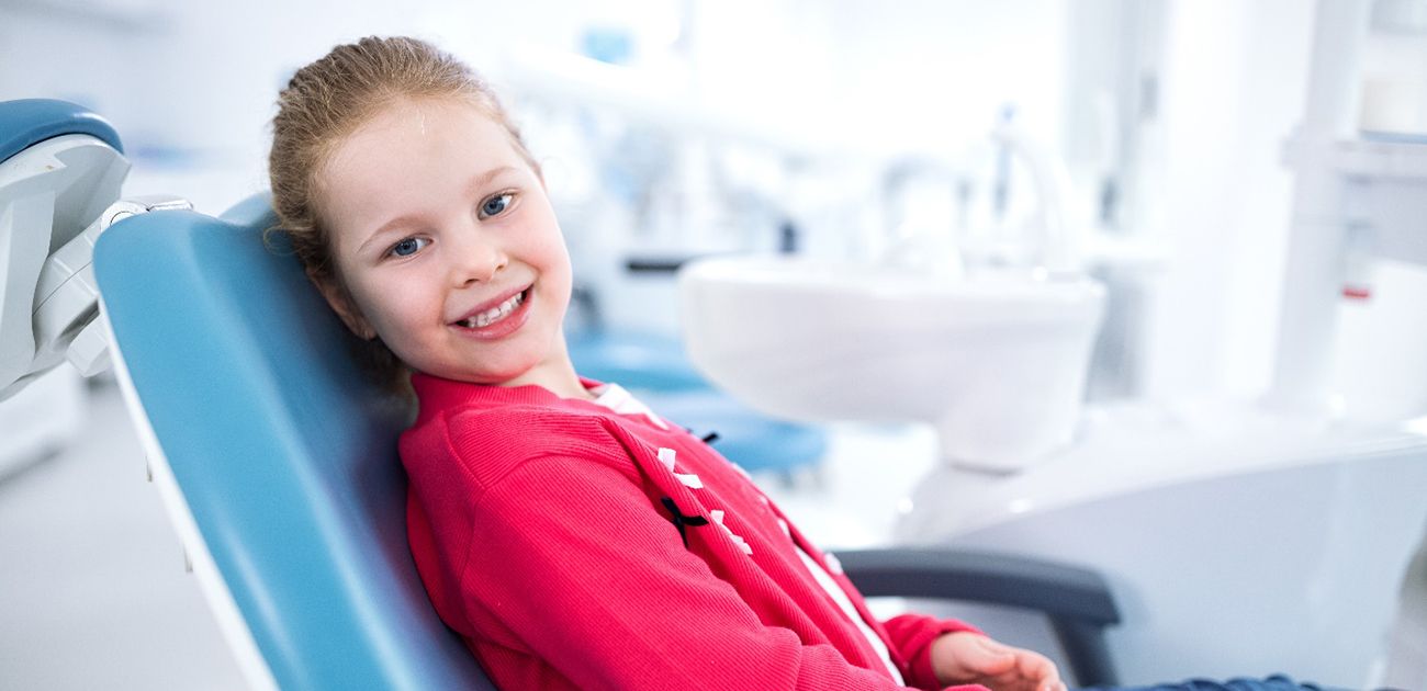 young girl smiling while in dental chair