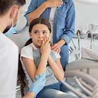 Child with toothache talking to pediatric dentist
