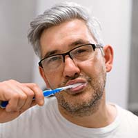 Man brushing his teeth to prevent dental emergencies in Temple