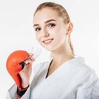 Closeup of woman in boxing gloves holding mouthguard in Temple