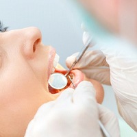 Woman receiving a dental exam from an emergency dentist in Temple