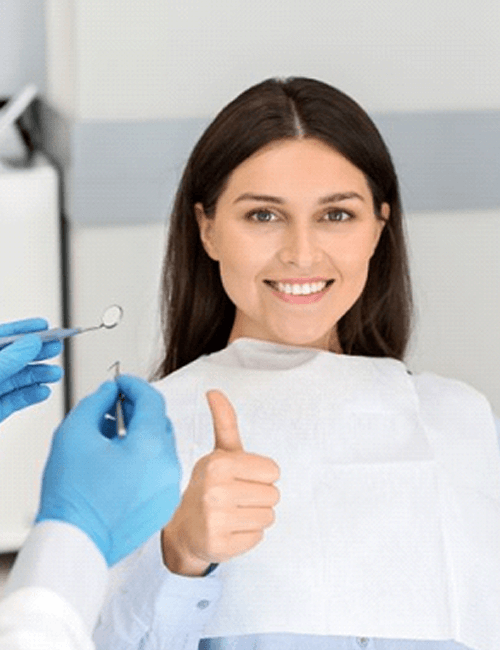 female dental patient making thumbs up gesture