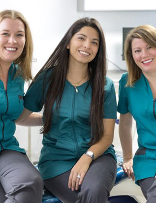 three smiling members of dental team