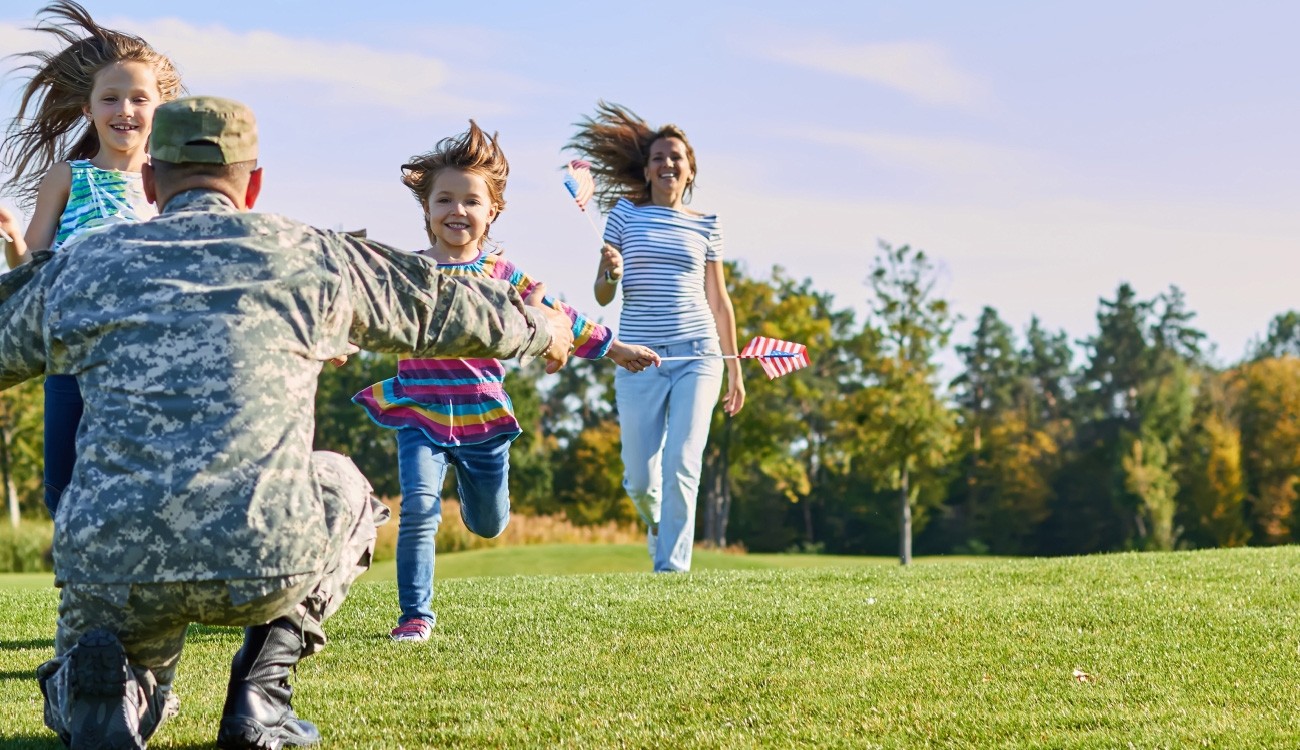 Military service man greeting laughing children running towards him