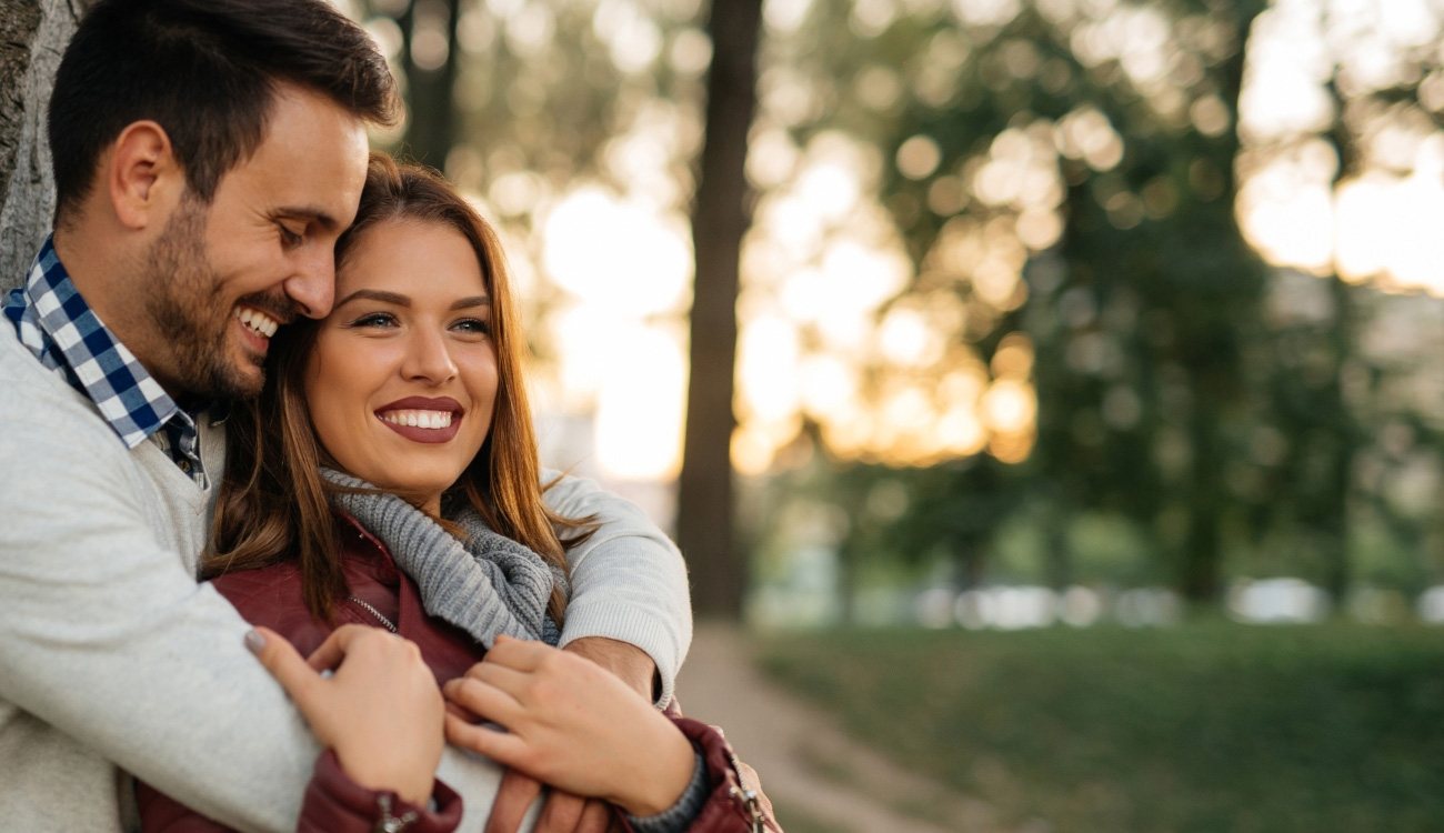 Man and woman with healthy smiles outdoors