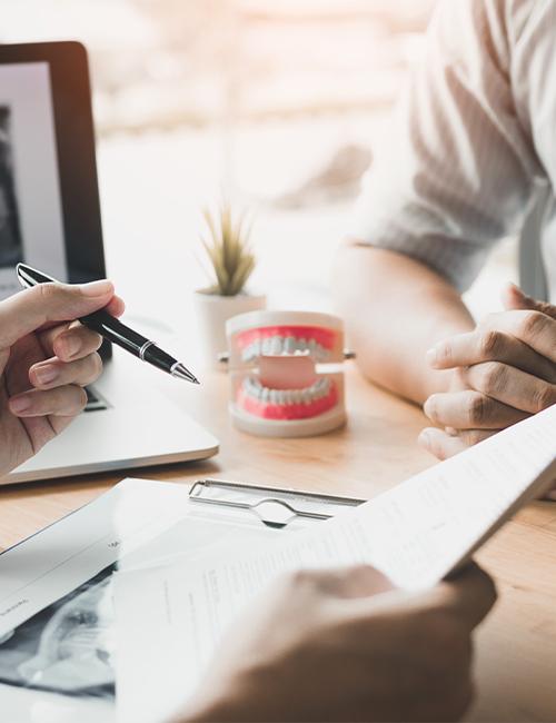 Dentist and patient reviewing dental insurance forms