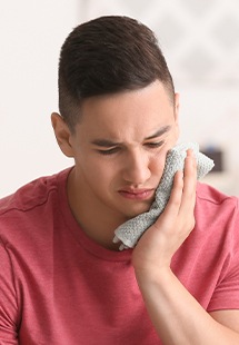 man holding his mouth from tooth pain in Belton