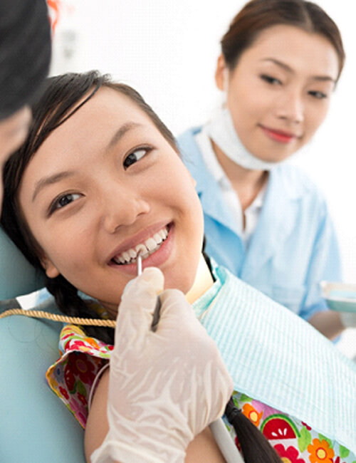 A female teenager having her teeth checked by a Medicaid dentist in Temple