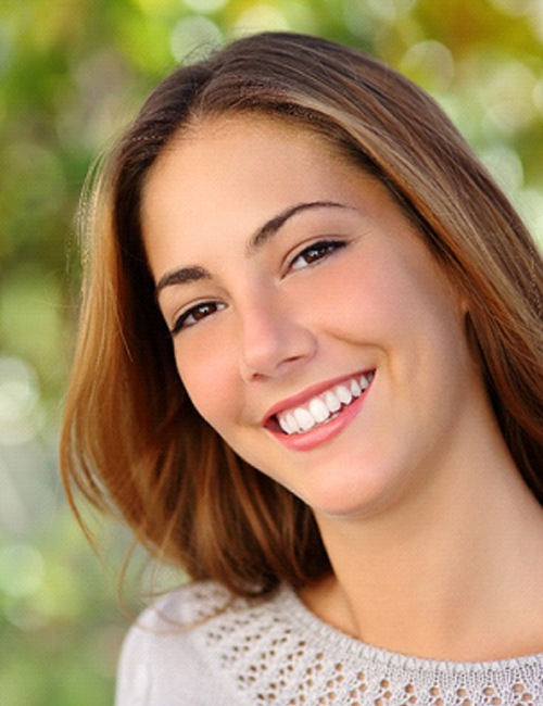 Woman outside and smiling after teeth whitening in Temple, TX