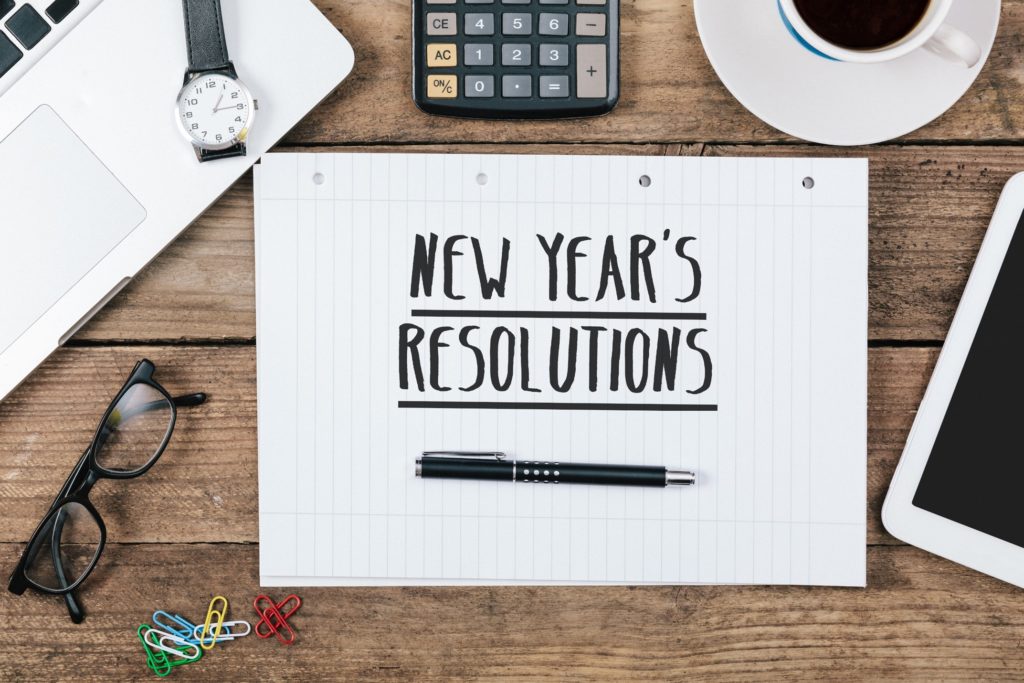 New Year's resolutions on notepad and desk