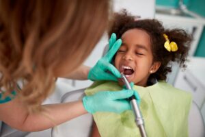 Dentist working on child's mouth.